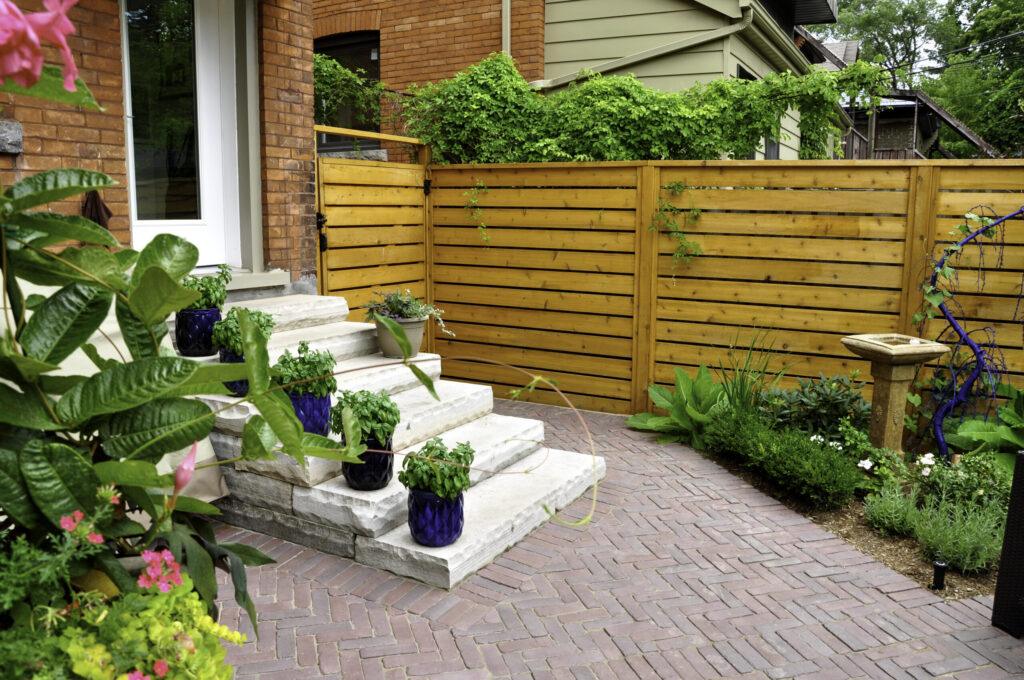 Luxury urban garden detail of natural stone steps, patio and flower beds.