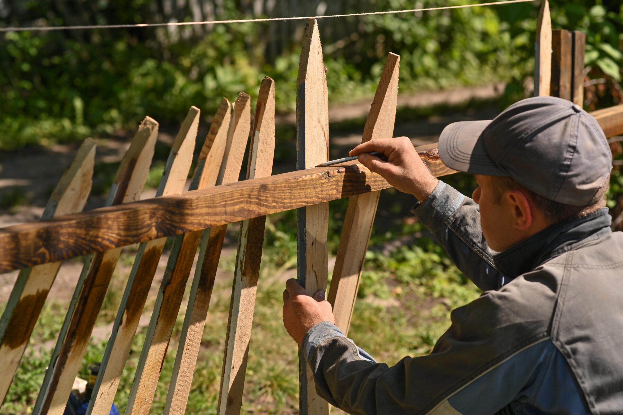 A Carpenter Marks Out Boards For Making A Fence In