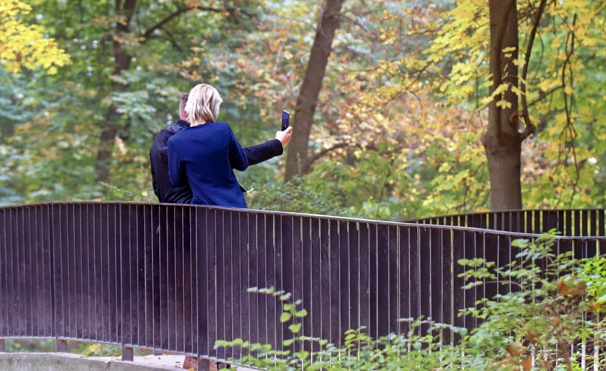 A Woman Is Taking A Picture Of A Fence And A Fence