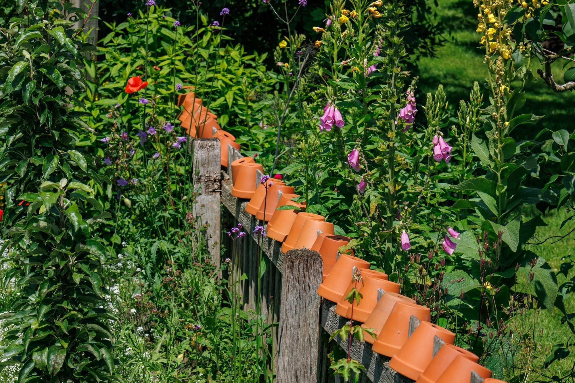 A Wooden Fence With Potted Plants And Flowers In F