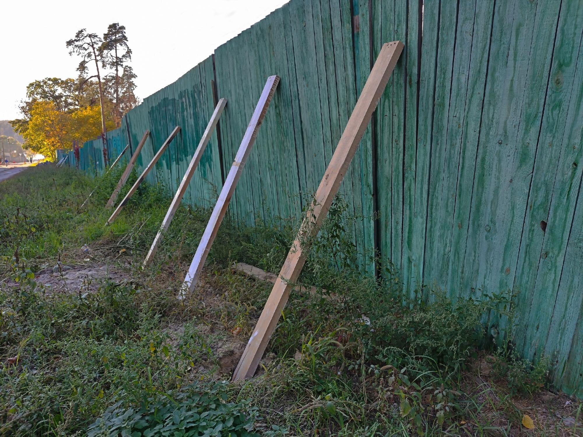 An Old Wooden Fence Supported By Several Boards In
