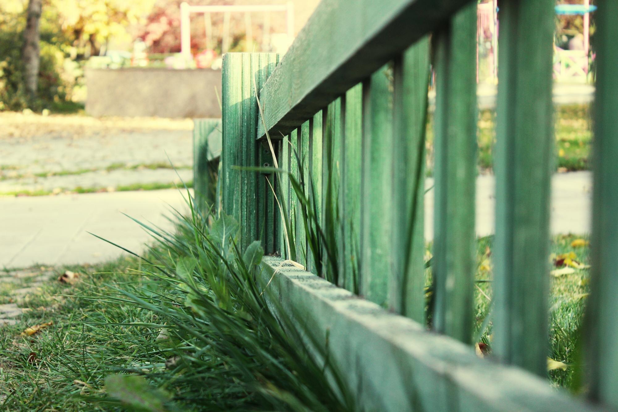 Close Up Of Green Wooden Fence On Field