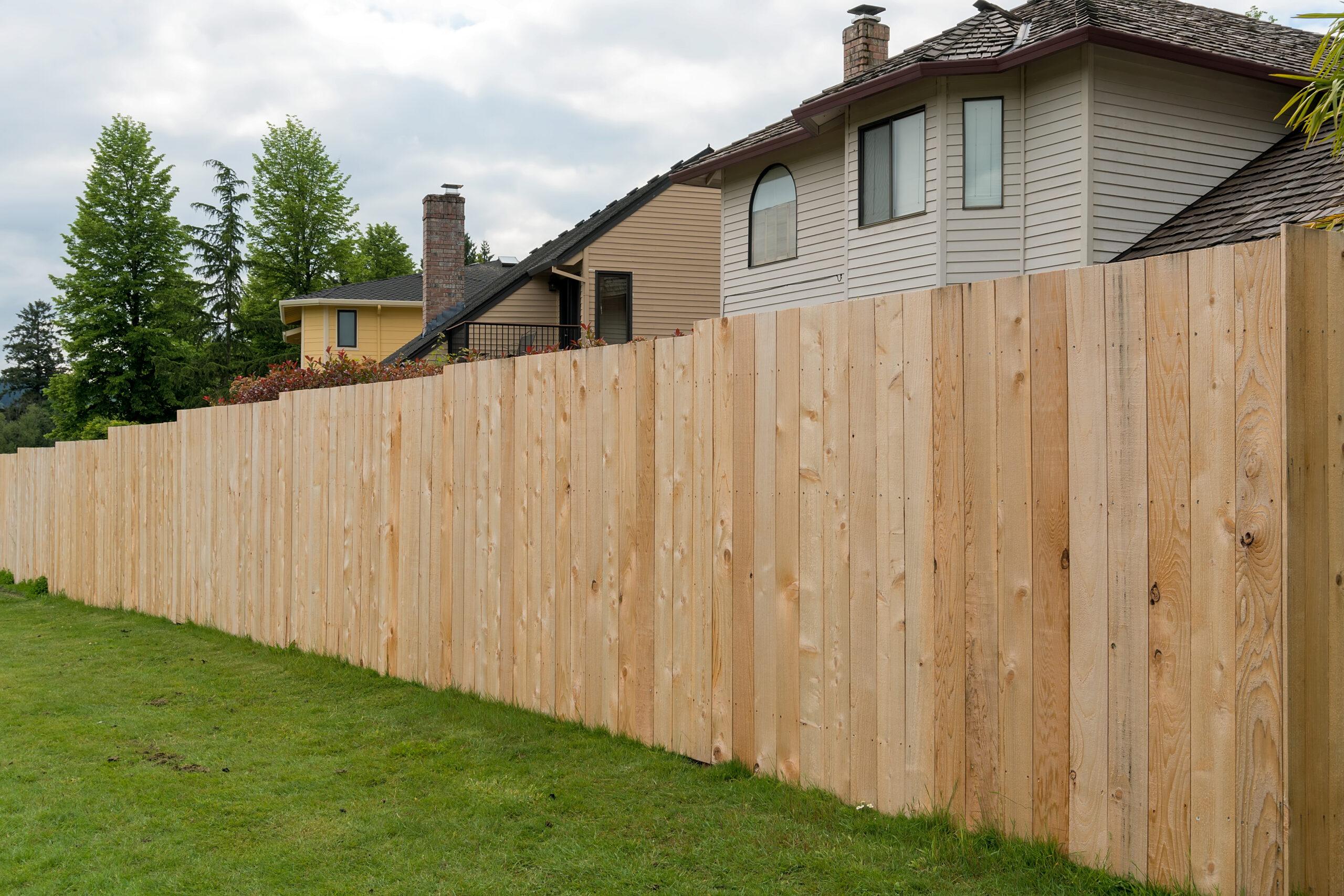 New Cedar Wood Fence Boards Along Homes In Suburba