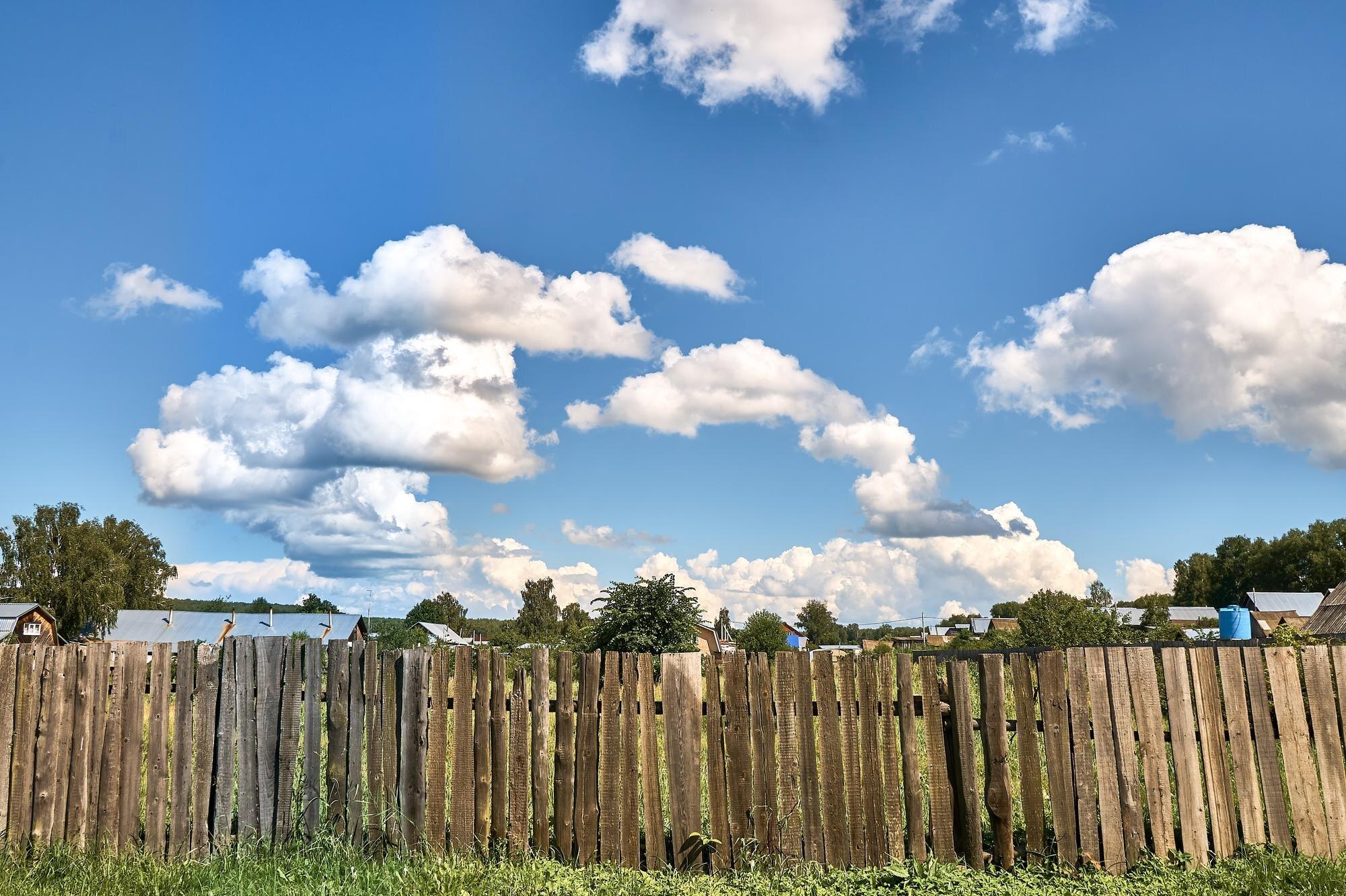 Old Wooden Fence Against The Background Of Clouds
