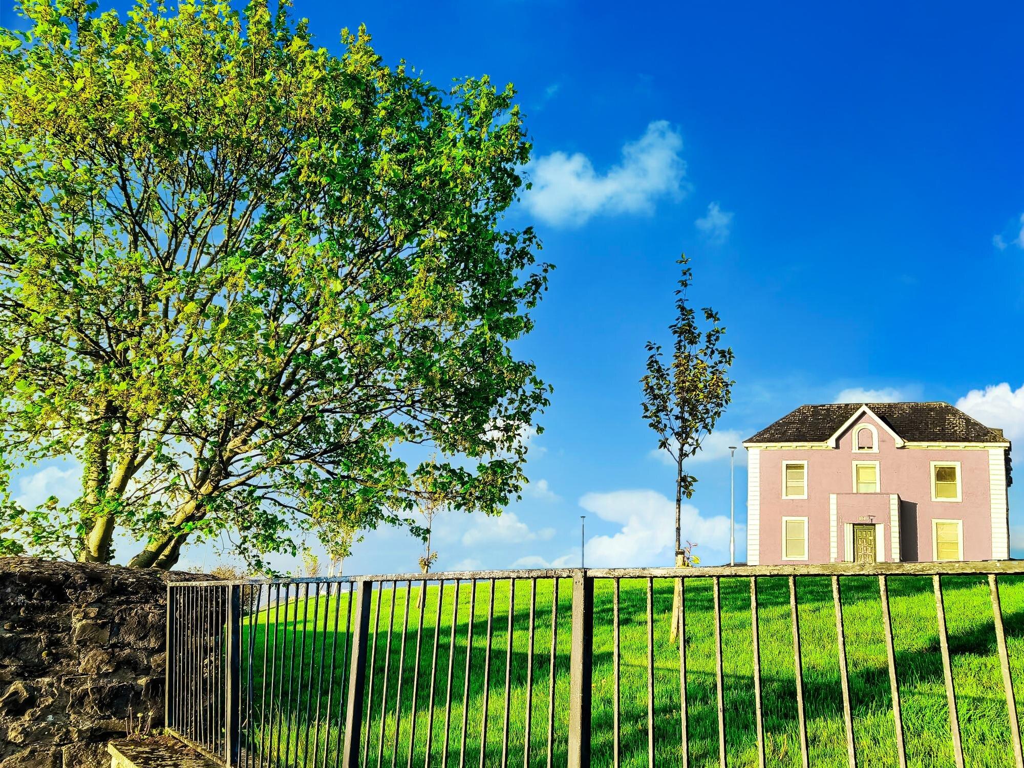 Pretty Irish House With Vivid Green Grass Old Rail