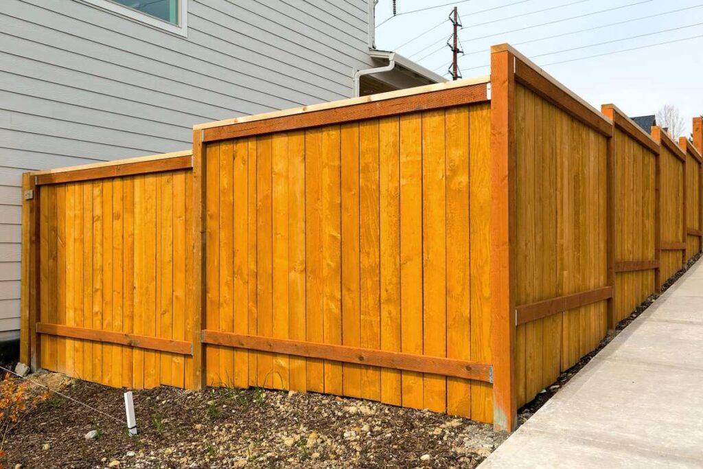 New wood privacy fence installed along the side of a standard home